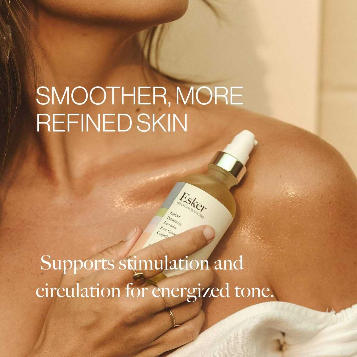 Woman applying Esker Firming Oil Deluxe Mini to her shoulder for smoother, more refined skin