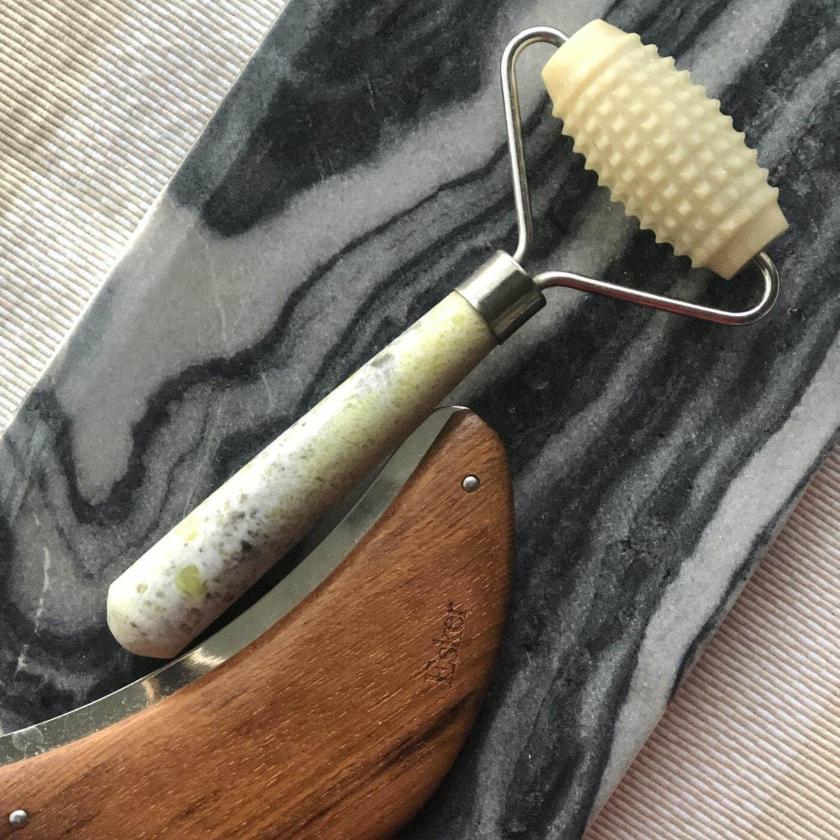 Esker Allover Roller with textured stone head resting on marbled fabric