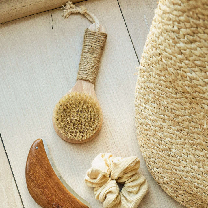 Esker Natural Bristle Dry Brush laid flat with a comb and hair scrunchie