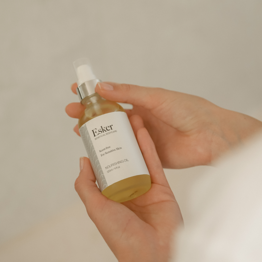 Hand holding a bottle of Esker Nourishing Oil